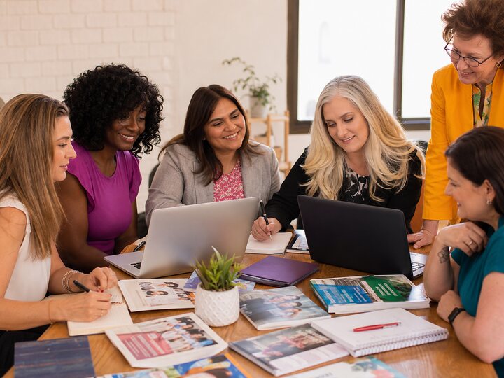Women collaborating around community resources and local impact projects.